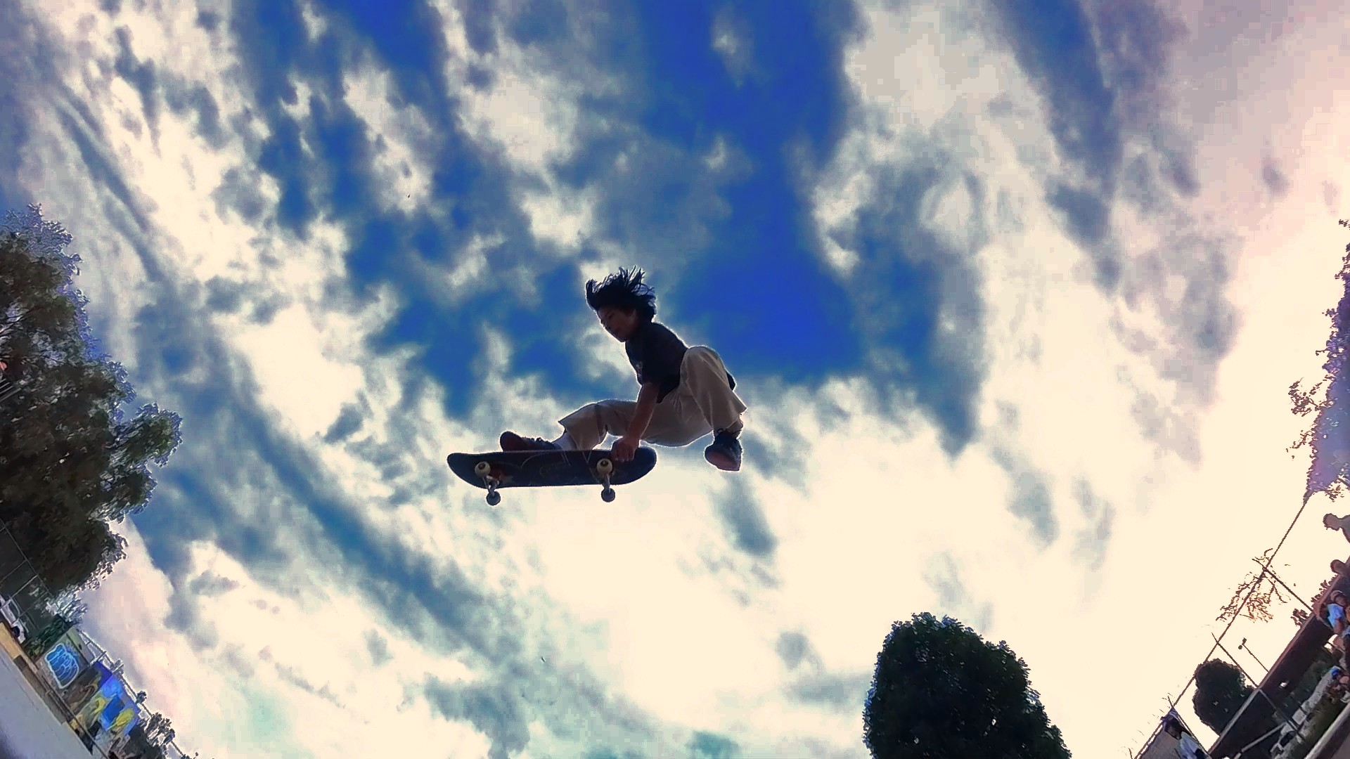 Skater catching air against a bright blue sky